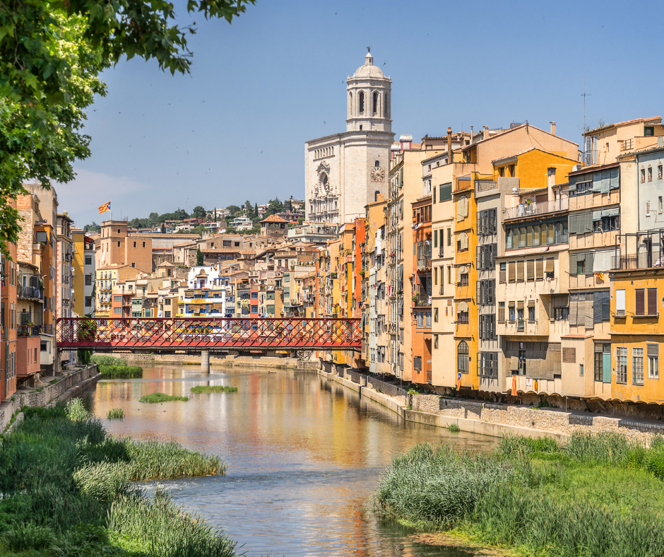 Medieval houses on the banks of the River Onyar, the Eiffel Bridge, and the bell tower in Girona, Catalonia, Spain