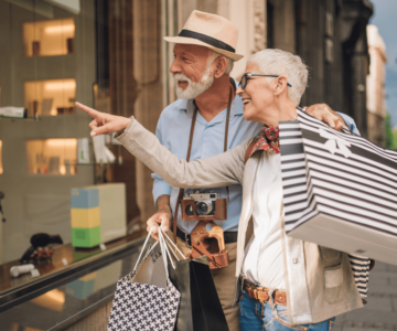 senior couple walking by store window