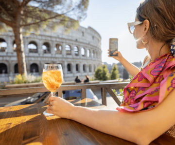 woman drinking spritz aperol at outdoor cafe near coliseum, the most famous landmark in Rome